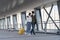 Couple of african tourists in protective masks walk with suitcase in airport terminal for departure