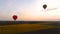 Couple air balloons flying over fields and electric cables, country development