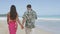 Couple In Aloha Clothing Walking On Hawaiian Beach