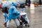 Couple with baby buggy at heavy rain