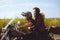 Couple on the background of the field rides a motorcycle. A man in a helmet rolls his girlfriend in a safety helmet. Road safety.