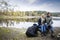 Couple With Backpack Relaxing On Lakeshore During Camping