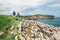 Couple backpacker travelers walk on ocean rocky coast