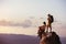 Couple backpackers on big rock at sunset