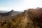 Couple backpackers walking ascending mountain ridge desert trai