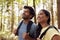 Couple With Backpacks Hiking Or Walking Through Woodland Countryside