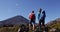 Couple With Backpacks Looking At Mount Ngauruhoe Against Blue Sky