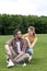 Couple with badminton racquet and shuttlecock resting on grass