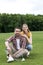 Couple with badminton racquets and shuttlecock resting on grass in park