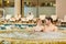 Couple in bathing suits in the pool resting spa center