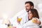 Couple in bathrobe drinking orange juice.