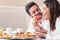 Couple in bathrobe having fun eating fruit.