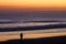 Couple at beach by dusk watching surfers