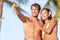 Couple on beach happy in swimwear, man pointing