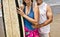 Couple on the beach holding surfing board