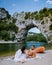 Couple on the beach by the river in the Ardeche France Pont d Arc, Ardeche France,view of Narural arch in Vallon Pont D