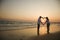 Couple on beach at sunset.