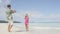 Couple on beach taking pictures with smart phone