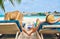 Couple at beach on wooden sun bed loungers