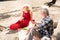 Couple of beaming pensioners drinking wine and eating salad during picnic