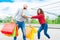 Couple of a bearded bald man and a brunette curly woman making shopping during black friday sales. happy boy and a girl making fun