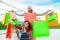 Couple of a bearded bald man and a curly caucasian woman inside a shopping cart holding paper bags during black friday sales.group