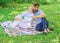 Couple bearded man and blonde woman relax nature while sit on green grass meadow. Relax and inspiration concept. Family