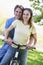 Couple on a bike outdoors smiling