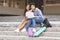 Couple of black teens sitting on stairs with laptop