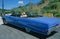 Couple in a blue Buick Electra convertible