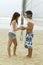 Couple Both Holding Volleyball under Net on Beach