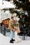 Couple with bouquet and bag with mandarins near christmas tree