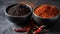 a couple of bowls filled with different types of spices next to each other