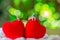 Couple of boy and girl miniature, small model figure sitting on red heart shape on white cotton with green bokeh background. Copy