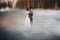 Couple bride in whire and groom in gray standing among lake.