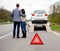 Couple and broken car on a highway