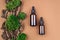 Couple of brown serum or oil glass mock up bottles with pipette over natural brown background of tree bark and moss