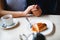 Couple in a cafe held by hand piece of cake