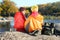 Couple of campers in sleeping bags sitting on rock