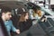 Couple in the car. Female dealership consultant shows a car to a young couple. Young family chooses auto at a car dealership