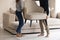 Couple carrying chair, placing furniture in new apartment cropped
