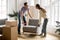 Couple carrying chair together, placing furniture moving in new