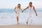 Couple in casual summer clothes having fun in ocean water