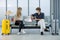 Couple Caucasian lovers man and woman with mask sit on chair with social distance and discuss together in airport during flight