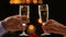 Couple celebrating New Year holding glasses with champagne, close-up hands