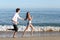 Couple chasing and running on the beach shore