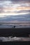 Couple and child play on the beach in the last light of the day reflection of clouds in puddle