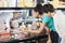 Couple Choosing Product From Display Cabinet While Saleswoman He