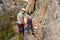 Couple of climbers prepares the knots and belays to start climbing while the girl climber looks on smiling