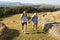 Couple Climbing Hill On Hike Through Countryside In Lake District UK Together